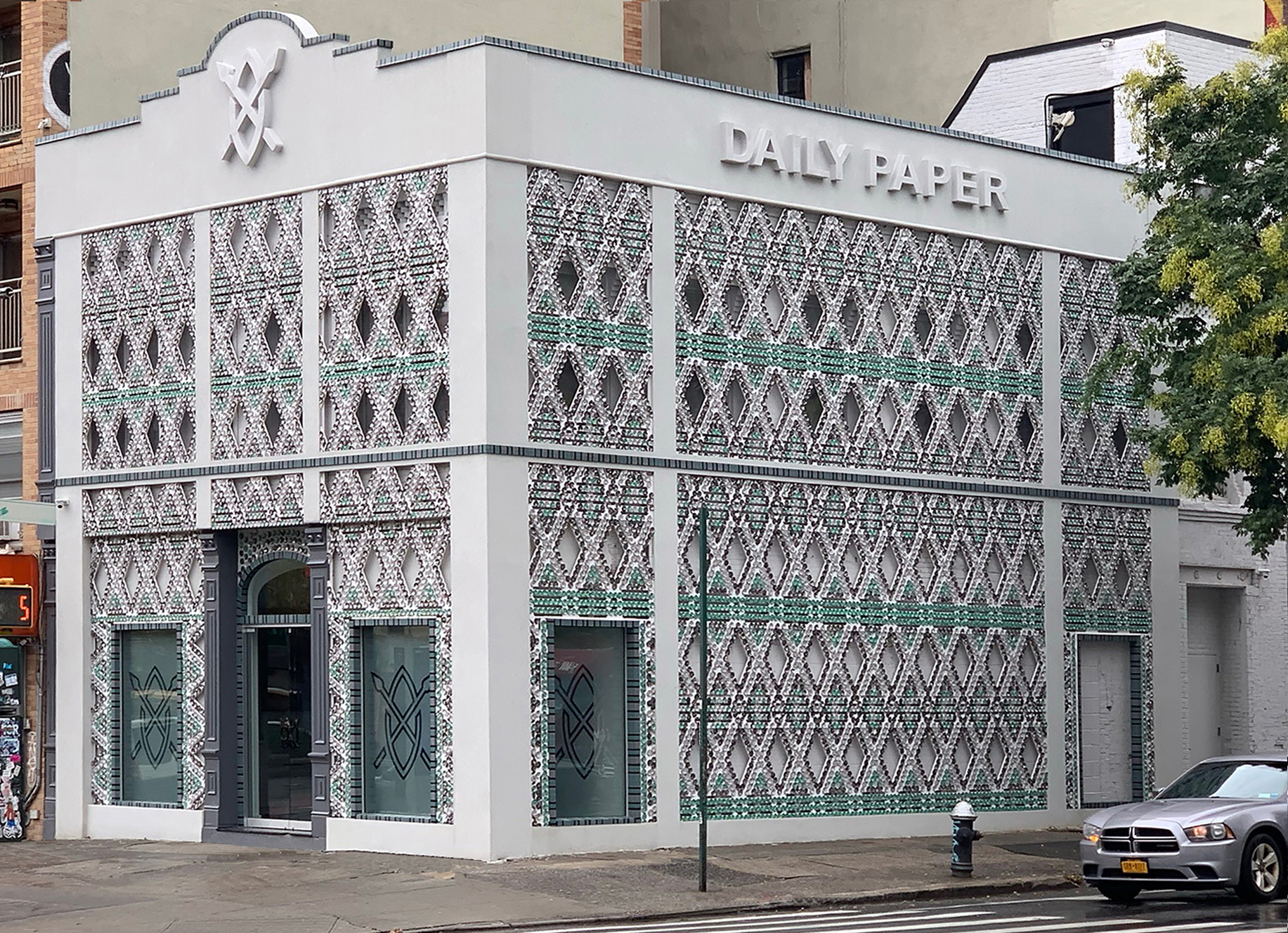 Design by architect Heather Faulding of flagship store for Daily Paper Clothing Store in the U.S. Three Founders of African heritage designed a brand to reflect "Pan-African pride and community." The store design blends their Dutch base with the very inventive ways of African design with recycling and found materials. The beadwork design on the facade was made with soda cans cut and folded by communities that the architect and contractor sponsored to help. Interior had a hidden stair so a glass floor and skylight above second floor draw the eye and experience to the second floor. Photography of facade by Andrew Matusik.